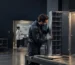 A technician inspects a shared-device storage unit during production, checking compartment fit before tablet lockers are packed for a healthcare project