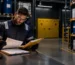 A site supervisor reviews a chemical inventory and safety data sheets beside organized storage zones as part of dangerous goods storage planning