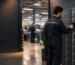A factory employee stores a personal phone before entering a device-restricted production area, supporting a clear workplace procedure.