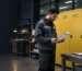A factory technician reviews an SDS beside chemical storage cabinets before selecting safe storage for workplace chemicals