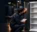 A quality technician checks a locker door and production records at an Istanbul metalworking facility while comparing details relevant to a locker warranty