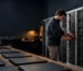 A school IT coordinator prepares a Chromebook charging cabinet fleet for classroom use between lessons.